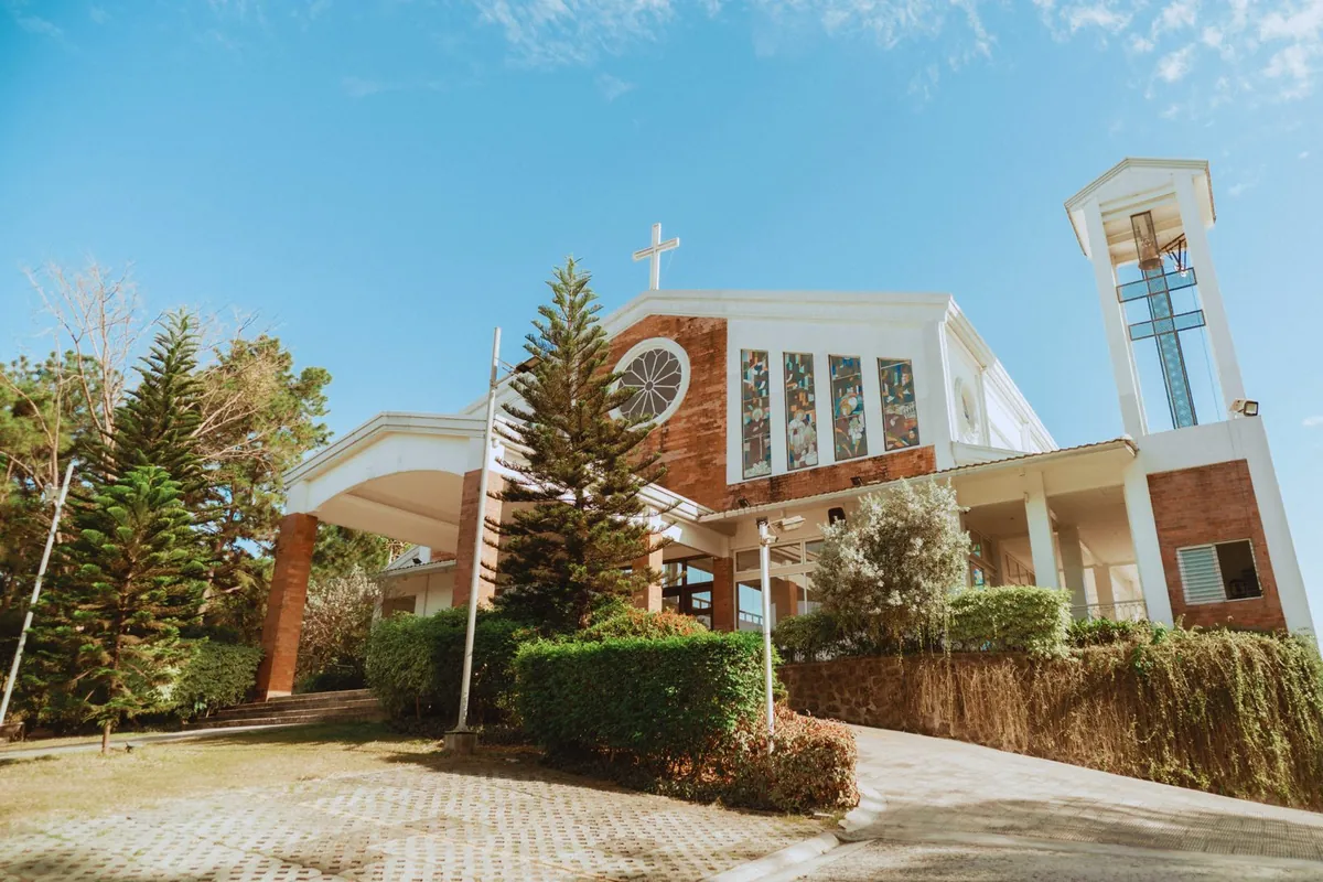 Church with a cross, bell tower and covered entrance on a sunny day
